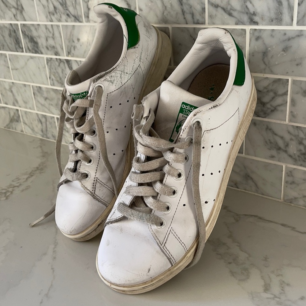 Adidas Stan Smith sneakers with green tab at heel.
